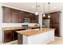Modern kitchen with dark wood cabinets, granite countertops, and stainless steel appliances at 12110 W Rowel Rd, Peoria, AZ 85383