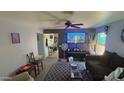 Comfortable living room featuring a ceiling fan, patterned rug, and stylish decor, ideal for relaxing at 15729 W Lundberg St, Surprise, AZ 85374