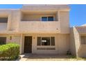 Two-story tan townhome featuring desert landscaping, patio, and a brown roof at 2155 W Farmdale Ave # 8, Mesa, AZ 85202