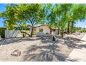 The home's exterior has desert landscaping, mature trees, and unique stone accents throughout the front yard at 28 E Winged Foot Rd, Phoenix, AZ 85022