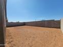 Spacious dirt backyard enclosed by a tall block wall, offering privacy and customization options at 3529 E Audrey Dr, San Tan Valley, AZ 85143
