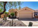 Tan single-story home showcasing a two-car garage, desert landscaping, and low-maintenance front yard at 41598 N Ranch Dr, San Tan Valley, AZ 85140