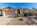 Charming single-story home featuring desert landscaping and a two-car garage with a neutral color palette at 41847 W Sparks Ct, Maricopa, AZ 85138