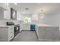 Modern kitchen featuring white cabinets, stainless steel appliances, and a large quartz countertop island at 4307 E Walatowa St, Phoenix, AZ 85044