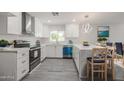 Bright kitchen with white cabinets, stainless steel appliances, quartz countertops, and a dining area at 4307 E Walatowa St, Phoenix, AZ 85044