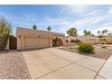 Spacious driveway leading to a single-story home with desert landscaping and an attached two-car garage at 4527 E Sunrise Dr, Phoenix, AZ 85044