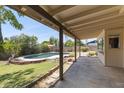 Inviting backyard featuring a covered patio overlooking a refreshing swimming pool and a well-maintained lawn at 4535 E Redfield Rd, Phoenix, AZ 85032