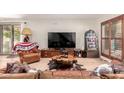 Bright living room featuring wood-look floors, a large TV, and rustic wood accents for a warm, inviting feel at 4812 E Winston Dr # 2, Phoenix, AZ 85044