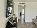 Bright living room featuring a large TV, tile floors, and open doorway at 538 E Glade Ave, Mesa, AZ 85204