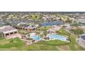 Community center featuring tennis courts, multiple pools, lush lawns, palm trees, and solar panel roofing at 6811 S Four Peaks Way, Chandler, AZ 85249