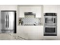 Elegant kitchen boasting stainless steel appliances, modern backsplash, and sleek countertops at 7508 N 13Th Ave, Phoenix, AZ 85021