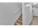 Carpeted stairs leading to an upper level, featuring white walls and a light-colored wood-look floor at 827 E Pecan Rd, Phoenix, AZ 85040