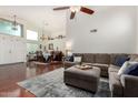 Bright living room featuring a comfortable sectional sofa, hardwood floors, and a view into the dining area at 9004 S Ash Ave, Tempe, AZ 85284