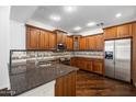 Well-appointed kitchen featuring wooden cabinetry, granite countertops, stainless steel appliances at 970 S Henry Ln, Gilbert, AZ 85296