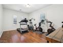 Well-equipped exercise room with hardwood floors, natural light, and various fitness machines for a complete workout at 9845 E Edgestone Dr, Scottsdale, AZ 85255