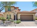Charming two-story home showcasing a tile roof, well-maintained landscaping, and a spacious two-car garage at 9845 E Edgestone Dr, Scottsdale, AZ 85255