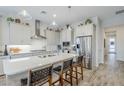 Modern kitchen featuring an island with seating, stainless steel appliances, and pendant lighting at 10509 W Harmony Ln, Peoria, AZ 85382