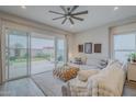 Cozy living room with a ceiling fan, sliding glass doors to the backyard, and comfortable seating at 10509 W Harmony Ln, Peoria, AZ 85382