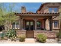 Charming front entrance with stone accents, wooden beams, and a cozy patio at 17665 N 93Rd Way, Scottsdale, AZ 85255