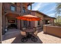 Outdoor patio area featuring a dining set with an umbrella and stone accents at 17665 N 93Rd Way, Scottsdale, AZ 85255