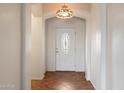 Inviting entryway featuring a decorative light fixture and elegant front door with an oval glass insert at 18222 W Lundberg St, Surprise, AZ 85388