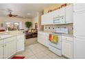 Bright kitchen with white cabinetry, tile backsplash, and stainless-steel appliances, open to the living room at 19607 N Flint Way, Surprise, AZ 85374