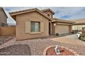 Charming home exterior showcasing desert landscaping, a two-car garage, and appealing architectural details at 21968 W Hadley St, Buckeye, AZ 85326