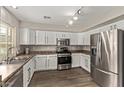 Well-lit kitchen showcasing stainless steel appliances, white cabinets, and hardwood floors at 2438 W Via Dona Rd, Phoenix, AZ 85085