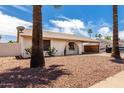 Charming single-story home with a front yard featuring desert landscaping and an attached carport at 2551 E Harmony Ave, Mesa, AZ 85204