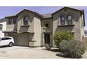 Attractive two-story home with arched windows, an attached garage, and a low-maintenance desert landscaped front yard at 25574 W Lynne Ln, Buckeye, AZ 85326
