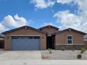 Charming single-story home with a gray garage door and desert landscaping at 37114 W La Paz St, Maricopa, AZ 85138