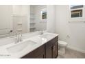 Bright bathroom featuring double sinks, a large mirror, and a window providing natural light and a clean design at 37371 W San Sisto Ave, Maricopa, AZ 85138