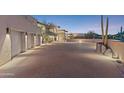 Paved driveway leading to a three-car garage, with desert landscaping and modern exterior lighting at 39602 N Charles Blair Macdonald Rd, Scottsdale, AZ 85262