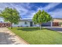 Charming single-story home featuring manicured landscaping, solar panels, and a spacious driveway at 4162 W Sierra St, Phoenix, AZ 85029