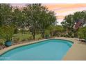 Sparkling pool featuring golf course views, privacy fence, and mature landscaping at 5029 S Carlyle Dr, Gilbert, AZ 85298