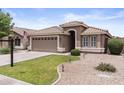 Charming home featuring a well-manicured lawn, neutral color palette, and a spacious two-car garage at 512 W Encinas St, Gilbert, AZ 85233