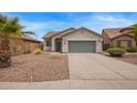 Charming home featuring a well-manicured front yard with gravel landscaping and a two-car garage at 695 S 221St Dr, Buckeye, AZ 85326