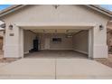 A spacious two car garage, complete with laminate floors, and a wall mounted air conditioning unit at 695 S 221St Dr, Buckeye, AZ 85326