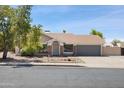 Charming home with a well-manicured lawn, desert landscaping, and a two-car garage at 7337 E Ivyglen St, Mesa, AZ 85207