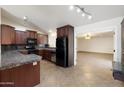 Kitchen with black appliances, dark wood cabinets, and granite countertops at 7337 E Ivyglen St, Mesa, AZ 85207
