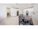 Bright kitchen featuring white cabinets, subway tile backsplash, stainless steel appliances, and a dining table at 7648 W Kerby Ave, Phoenix, AZ 85043