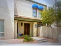 Multi-story townhome with a tiled entry roof, decorative lighting, flowers, and an ADT security sign at 8653 S 51St St # 2, Phoenix, AZ 85044