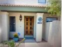 Close-up of a front door with tiled roof, decorative lighting, flowers, and a house number at 8653 S 51St St # 2, Phoenix, AZ 85044