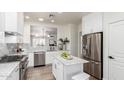 Open concept kitchen with stainless steel appliances, white cabinets, and a marble countertop island at 896 E Indian Wells Pl, Chandler, AZ 85249
