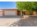 Charming single-story brick home with a two-car garage and a mature shade tree at 10032 N 50Th Dr, Glendale, AZ 85302