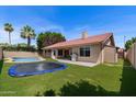 Spacious backyard featuring a pool, trampoline, artificial grass, and outdoor grill area at 11131 E Becker Ln, Scottsdale, AZ 85259