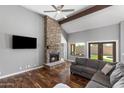 Living room features a fireplace, wood floors, large windows, and exposed beams at 11131 E Becker Ln, Scottsdale, AZ 85259