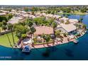 Waterfront home features a pool, boat dock, multiple patios, a built-in fireplace, and lush landscaping at 1241 W Lobster Trap Dr, Gilbert, AZ 85233