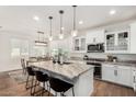 Open kitchen with white cabinets, marble countertops, and a view into the dining area at 1250 N Abbey Ln # 206, Chandler, AZ 85226