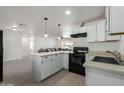 Modern kitchen with white cabinets, stone countertops, sleek appliances, and an open layout at 1408 E Orange St, Tempe, AZ 85281